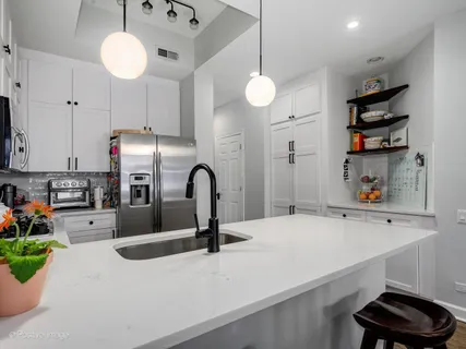 a kitchen with stainless steel appliances a kitchen island a stove and a refrigerator with wooden floor