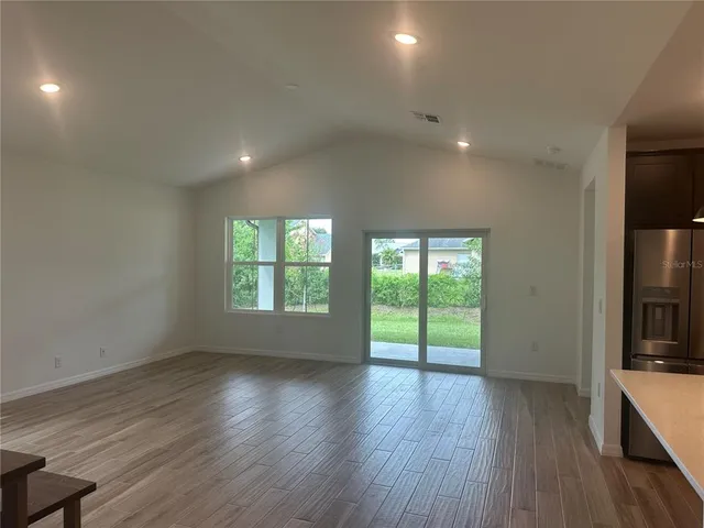 an empty room with wooden floor and a window