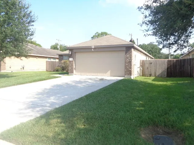 a view of a house with a yard and a large tree