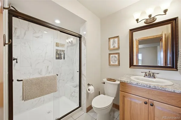 a bathroom with a granite countertop sink toilet and shower