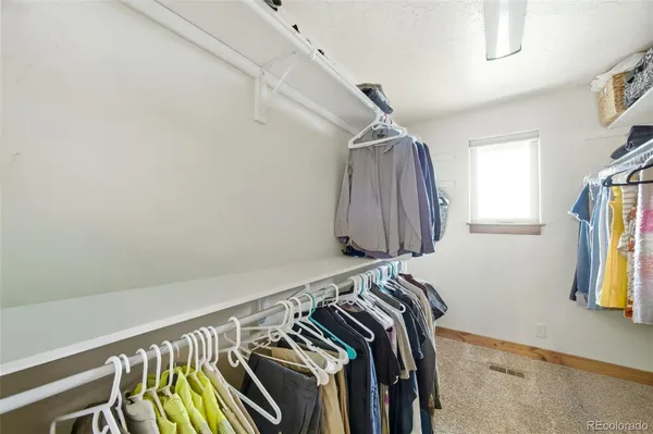 a view of walk in closet with clothes and shoes
