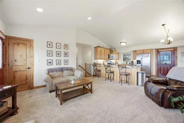 a living room with furniture and a dining table with wooden floor