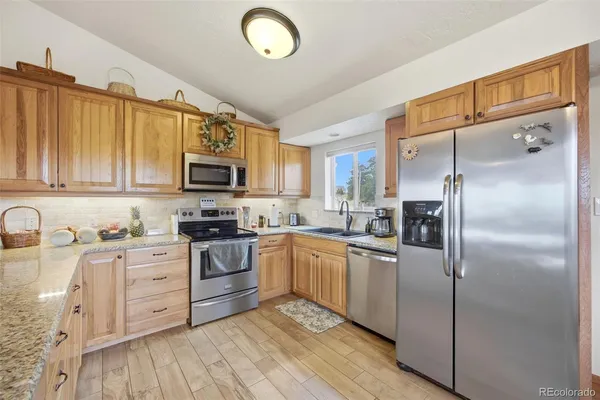 a kitchen with white cabinets stainless steel appliances and a counter space