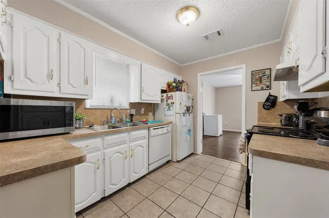 a kitchen with granite countertop white cabinets and white appliances