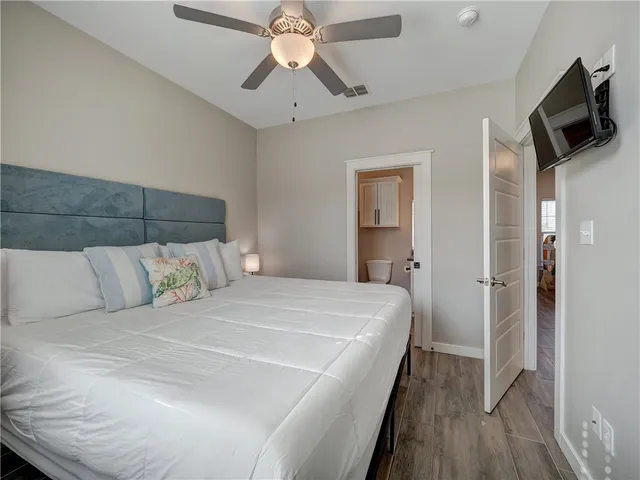 a bedroom with a large bed window and a ceiling fan