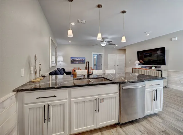 a kitchen with granite countertop a sink and cabinets
