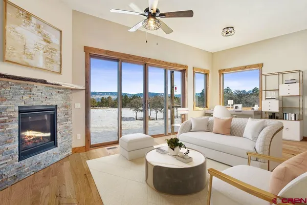 a living room with furniture fireplace and a large window
