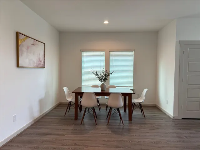 a view of a hallway with wooden floor and furniture