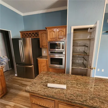a kitchen with granite countertop a refrigerator and a sink
