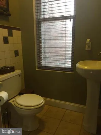 a bathroom with a toilet a sink and a window