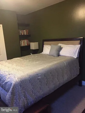 a bedroom with a bed and a book shelf