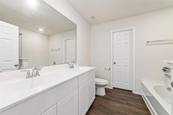 a bathroom with a double vanity sink toilet a tub and shower
