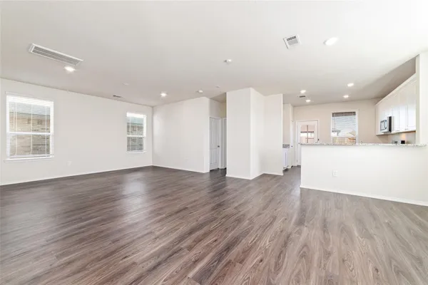 a view of a kitchen with wooden floor and windows