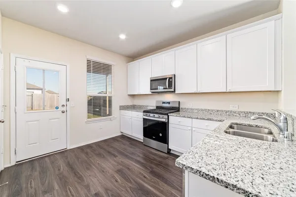 a kitchen with a sink stove top oven and cabinets