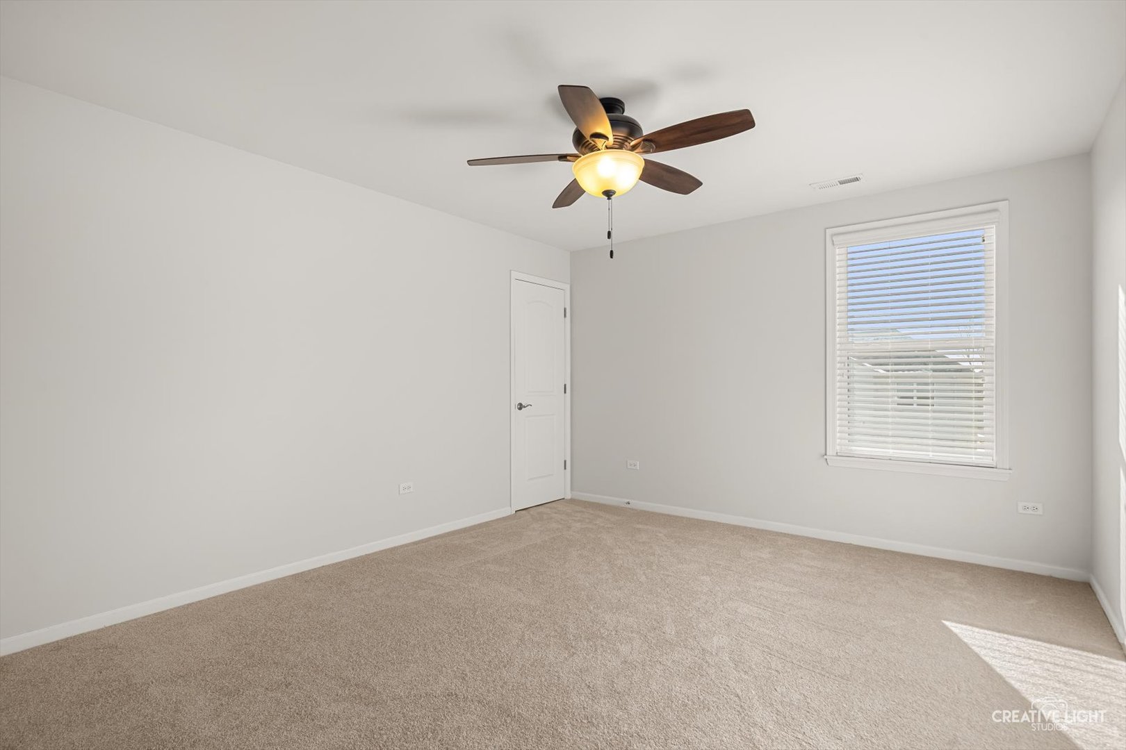 5332 Cedar Drive Naperville, IL 60564 - Photo 27 of 56 an empty room with a window and a fan