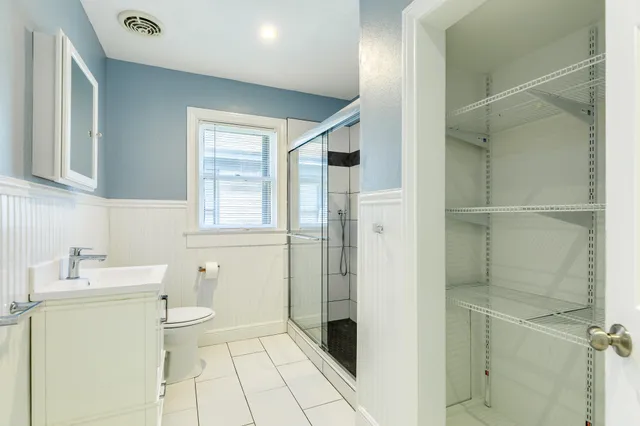 a bathroom with a granite countertop sink a toilet and a shower