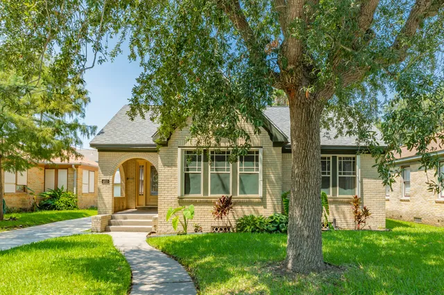 a front view of a house with a garden and yard