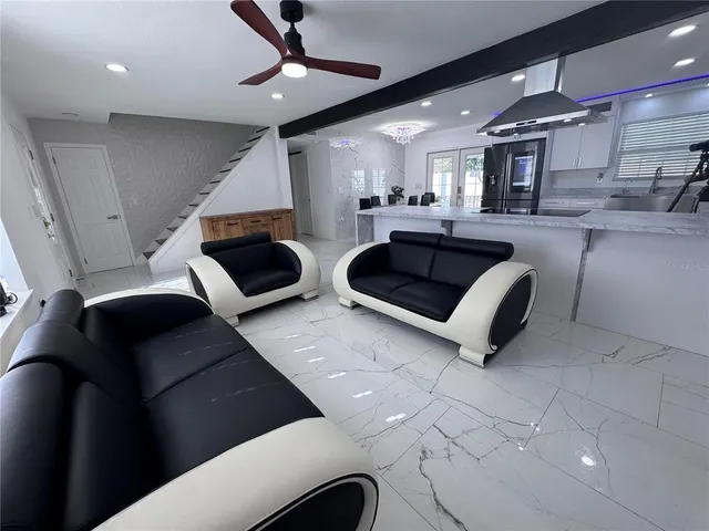 a kitchen with stainless steel appliances kitchen island granite countertop a refrigerator and a sink