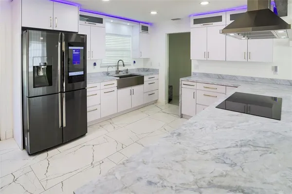 a kitchen with a dining table chairs refrigerator and a fireplace