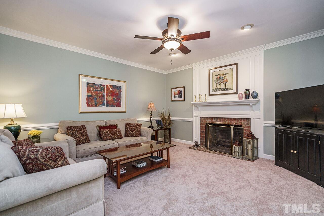 8601 Zinfandel Place Raleigh, NC 27615 - Photo 11 of 29 a living room with furniture a fireplace and a flat screen tv