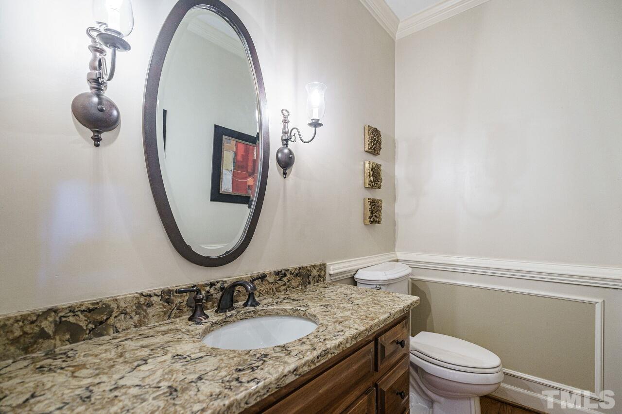 8601 Zinfandel Place Raleigh, NC 27615 - Photo 13 of 29 a bathroom with a granite countertop toilet a sink and mirror