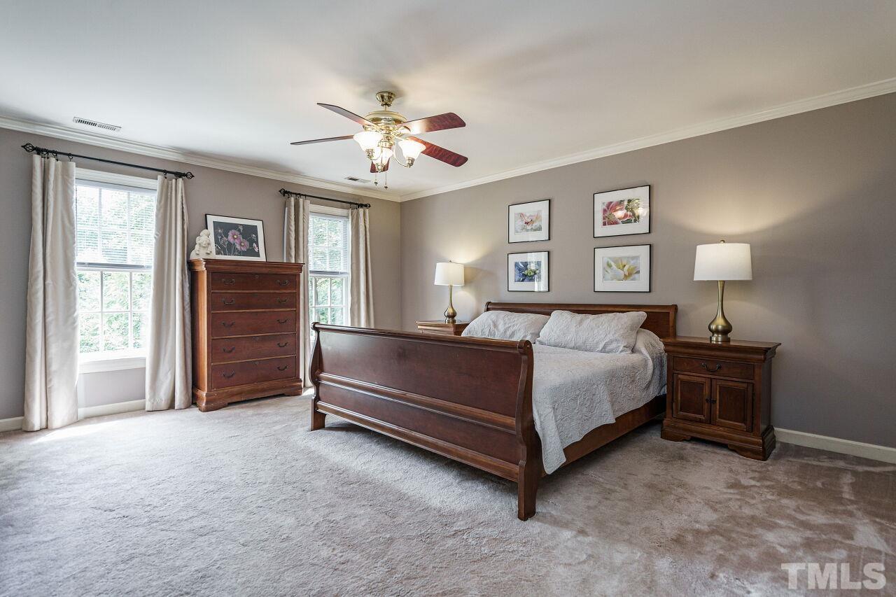 8601 Zinfandel Place Raleigh, NC 27615 - Photo 14 of 29 a spacious bedroom with a bed and a chandelier