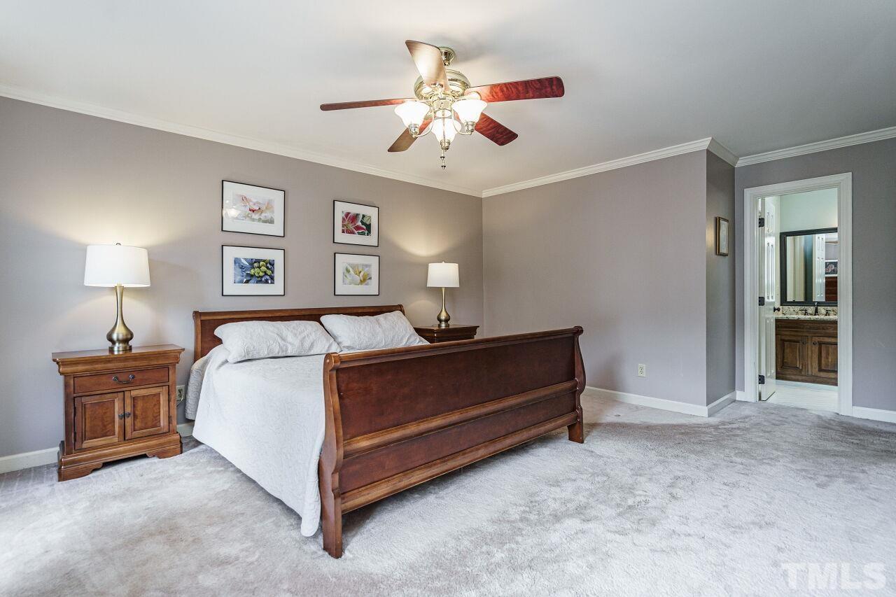 8601 Zinfandel Place Raleigh, NC 27615 - Photo 15 of 29 a spacious bedroom with a bed and a chandelier