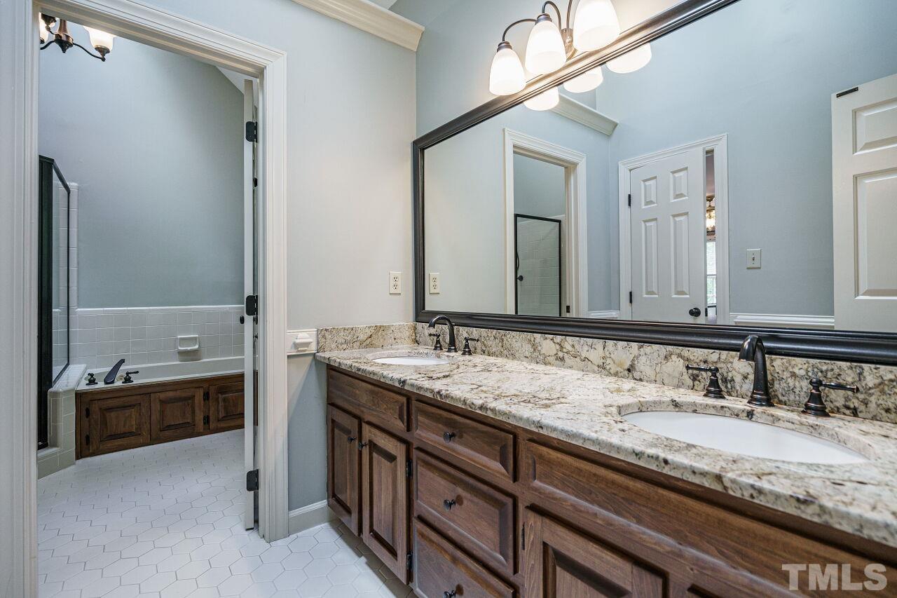 8601 Zinfandel Place Raleigh, NC 27615 - Photo 16 of 29 a bathroom with a granite countertop double vanity sink and a mirror