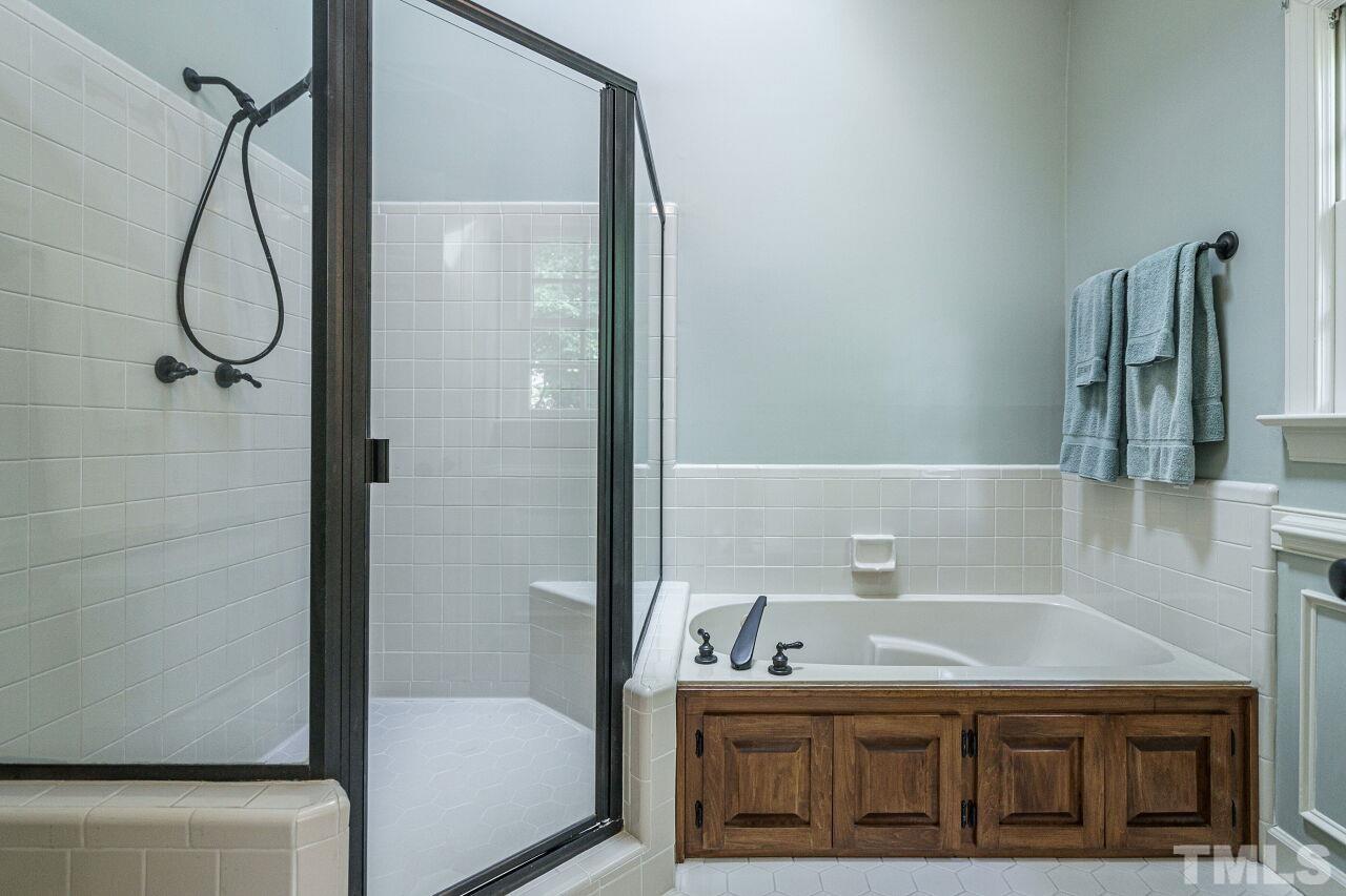 8601 Zinfandel Place Raleigh, NC 27615 - Photo 17 of 29 a bathroom with a tub and shower