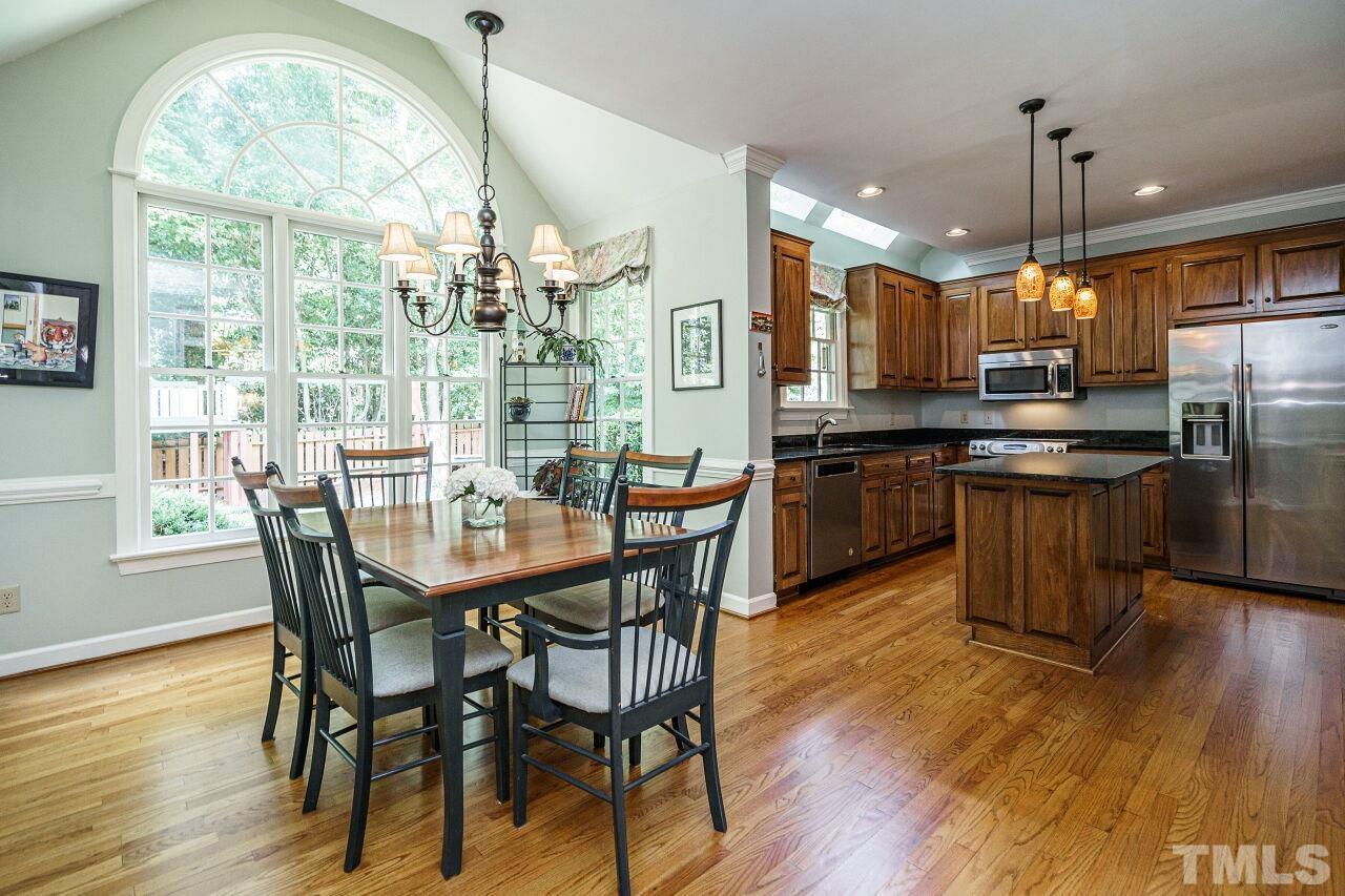 8601 Zinfandel Place Raleigh, NC 27615 - Photo 6 of 29 a kitchen with stainless steel appliances granite countertop a kitchen island hardwood floor and a view of living room