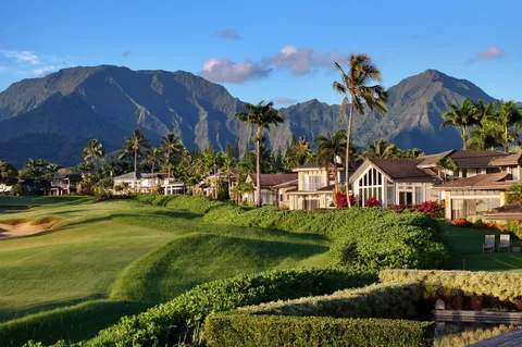a front view of a house with a yard and a garden