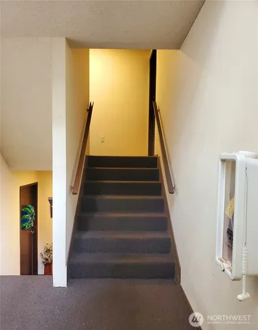 a view of staircase with wooden floor and a window