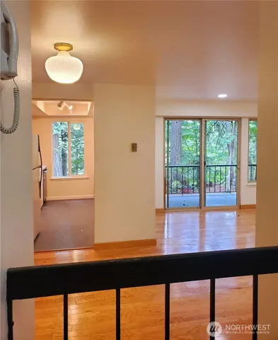 a view of a room with a large window and wooden floor
