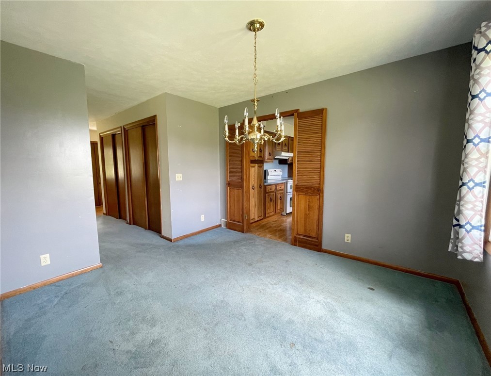 15508 West Calla Road Beloit, OH 44609 - Photo 6 of 19 Spare room with a notable chandelier and light carpet