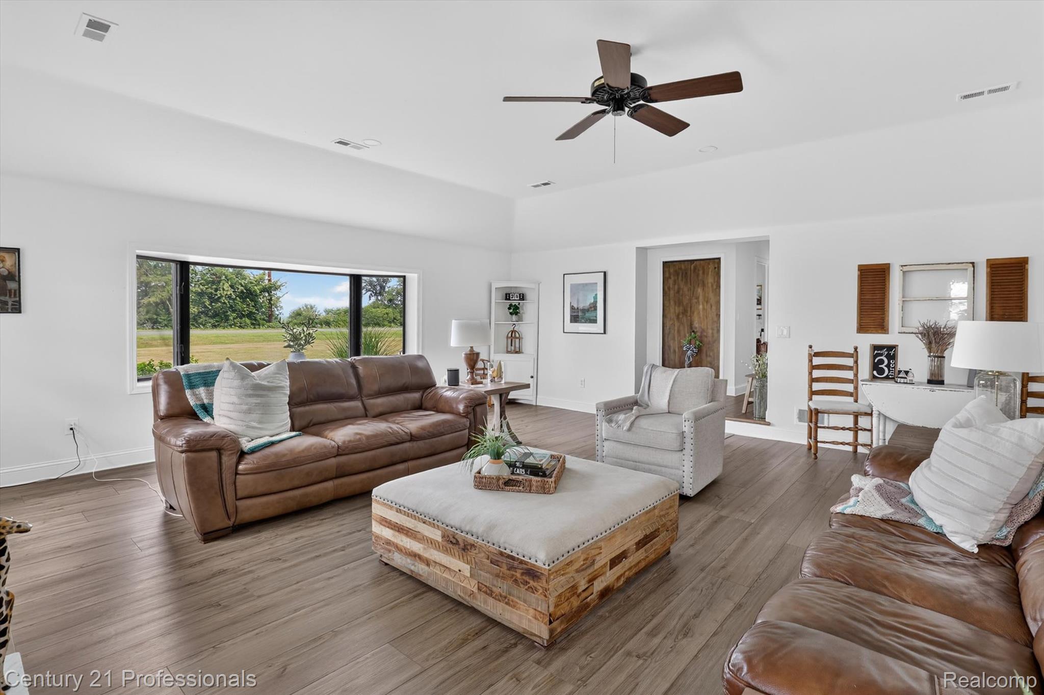 13525 Dennison Road Milan, MI 48160 - Photo 15 of 69 Spacious living area featuring high vaulted ceilings, modern wood-finish flooring, and a large picture window