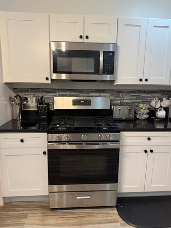a kitchen with stainless steel appliances granite countertop a stove and a microwave