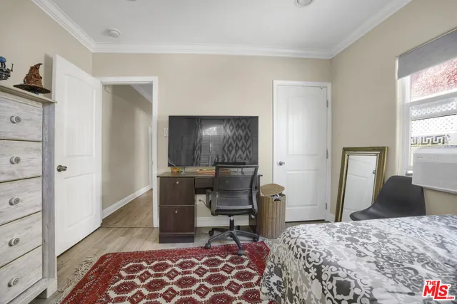 a bedroom with a bed and large windows