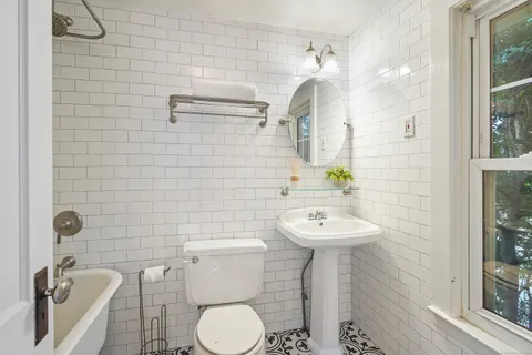 a bathroom with a sink a toilet and mirror