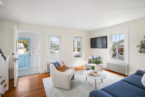 a living room with furniture wooden floor and a flat screen tv