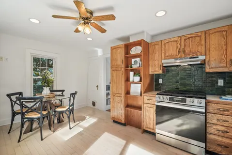 a kitchen with stainless steel appliances granite countertop a stove top oven a refrigerator and cabinets