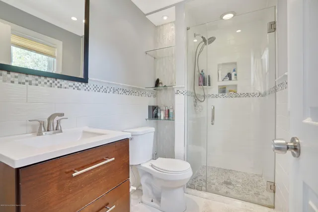 a bathroom with a sink a toilet and shower