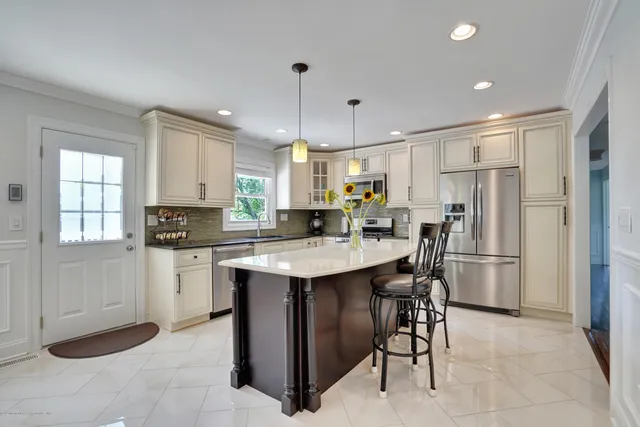 a kitchen with kitchen island a sink stove and refrigerator