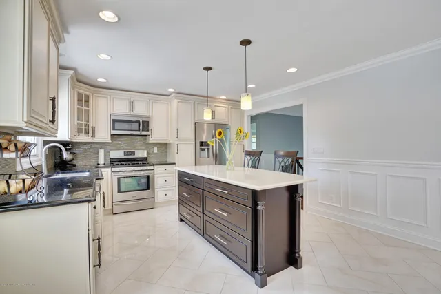 a kitchen with kitchen island white cabinets stainless steel appliances and sink