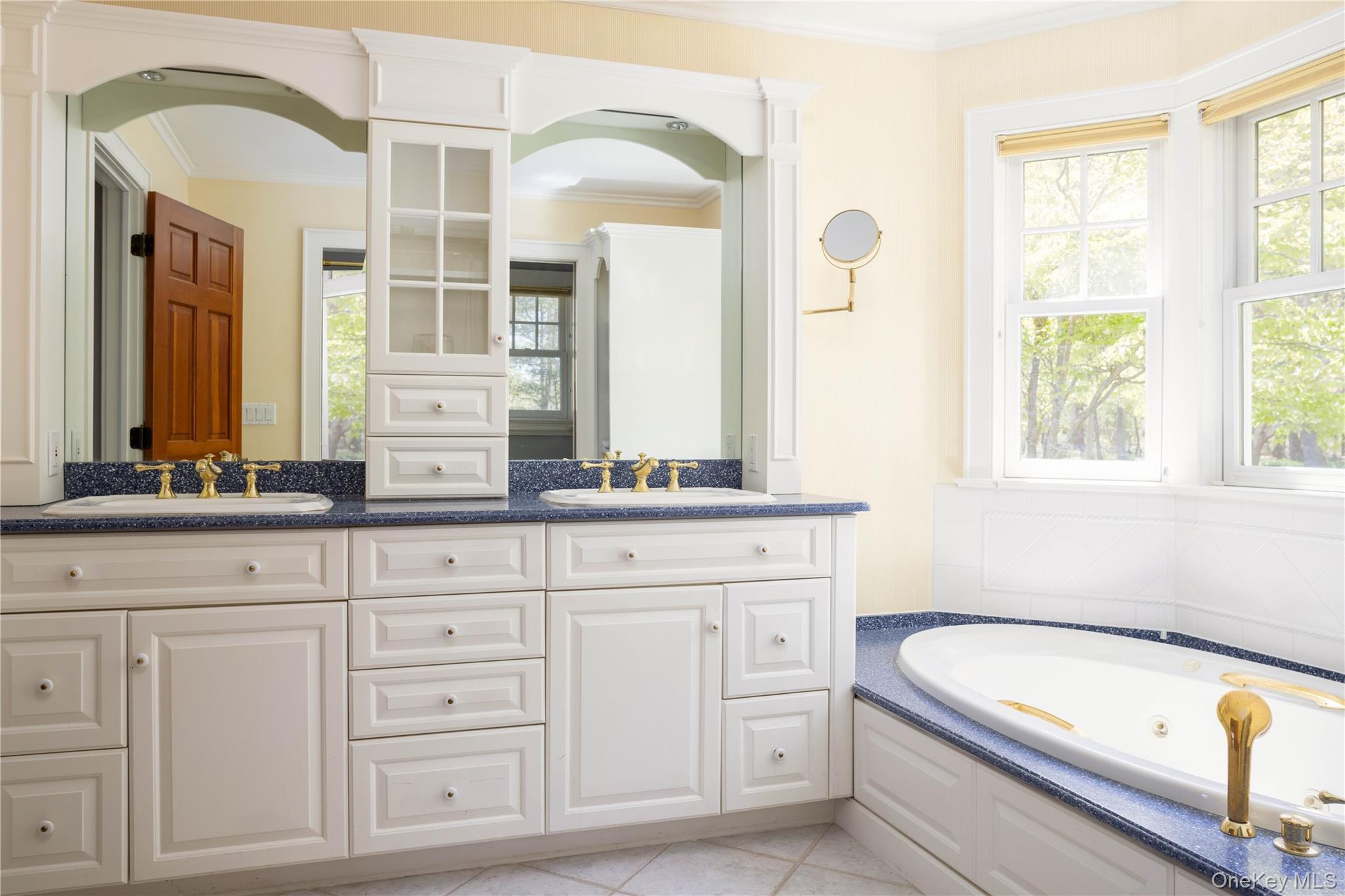 5055 New Suffolk Road New Suffolk, NY 11956 - Photo 22 of 42 a bathroom with a bathtub a double vanity sink and mirror