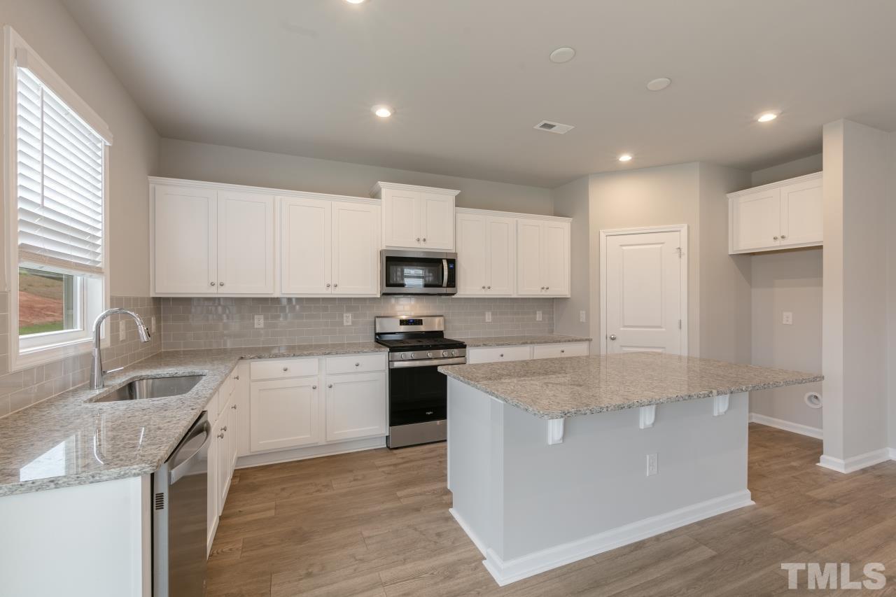 249 Pierce Lndg Drive Garner, NC 27529 - Photo 4 of 11 a kitchen with stainless steel appliances granite countertop a sink stove and refrigerator