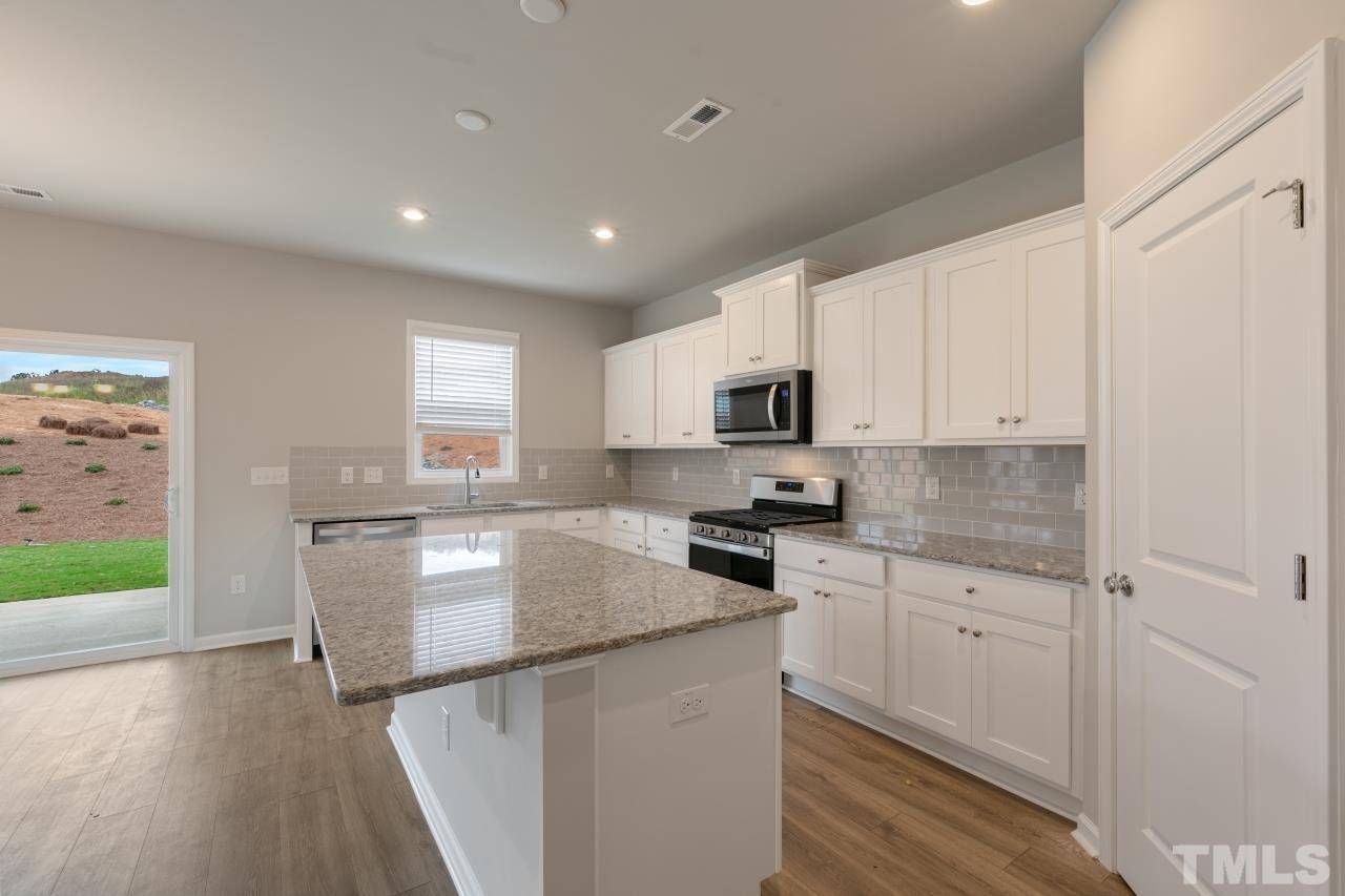 249 Pierce Lndg Drive Garner, NC 27529 - Photo 5 of 11 a kitchen with kitchen island granite countertop a sink cabinets and stainless steel appliances