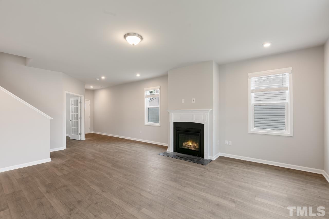 249 Pierce Lndg Drive Garner, NC 27529 - Photo 6 of 11 an empty room with windows and a fireplace