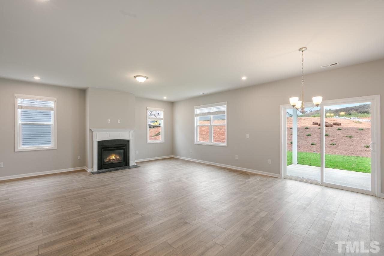 249 Pierce Lndg Drive Garner, NC 27529 - Photo 8 of 11 a view of a livingroom with wooden floor a fireplace and window