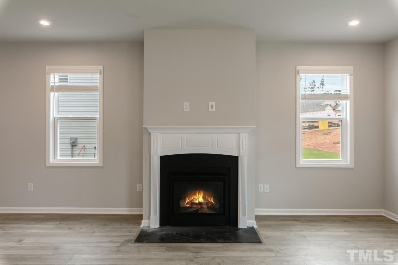 249 Pierce Lndg Drive Garner, NC 27529 - Photo 9 of 11 a living room with furniture a fireplace and a window