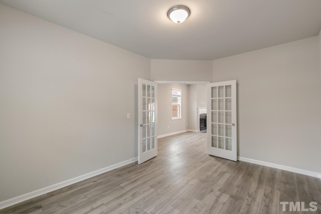249 Pierce Lndg Drive Garner, NC 27529 - Photo 10 of 11 an empty room with wooden floor and windows